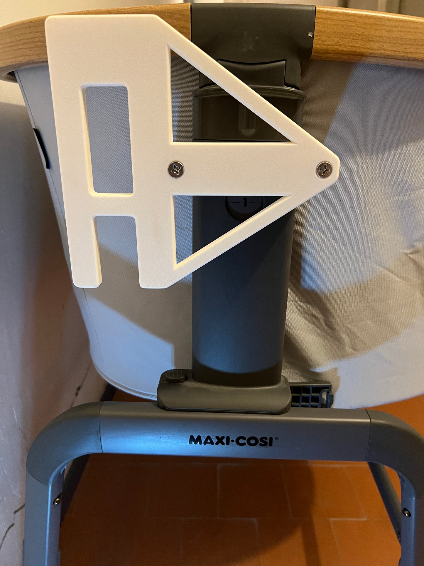 White adapter bracket attached to the maxi cosi iora co-sleeper